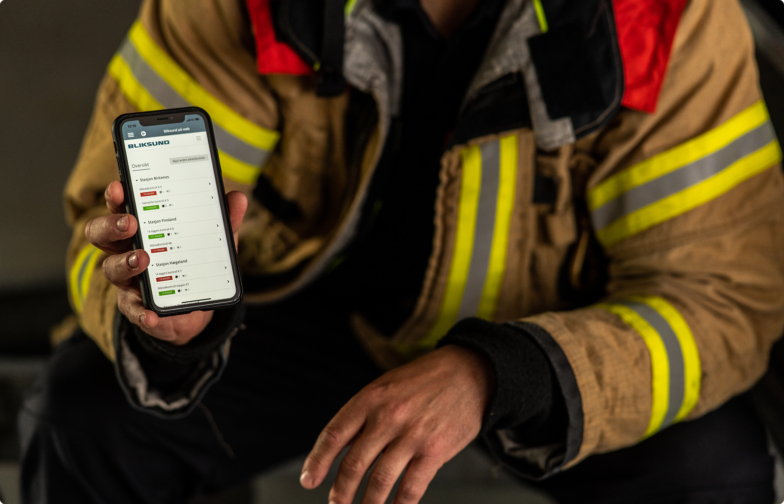 Feuerwehrmann zeigt das professionelle Einsatzsystem GRID auf einem Smartphone